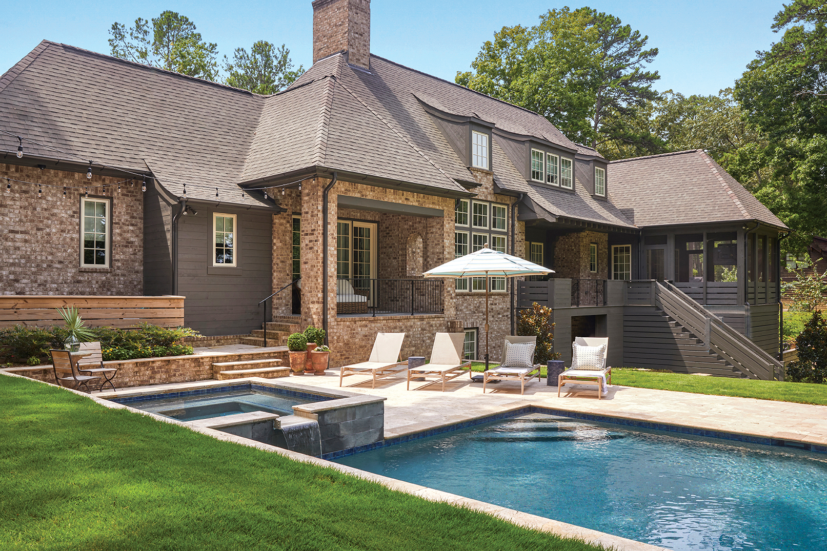 Back elevation of home, sporting a hot tub, pool, and screened-in porch.