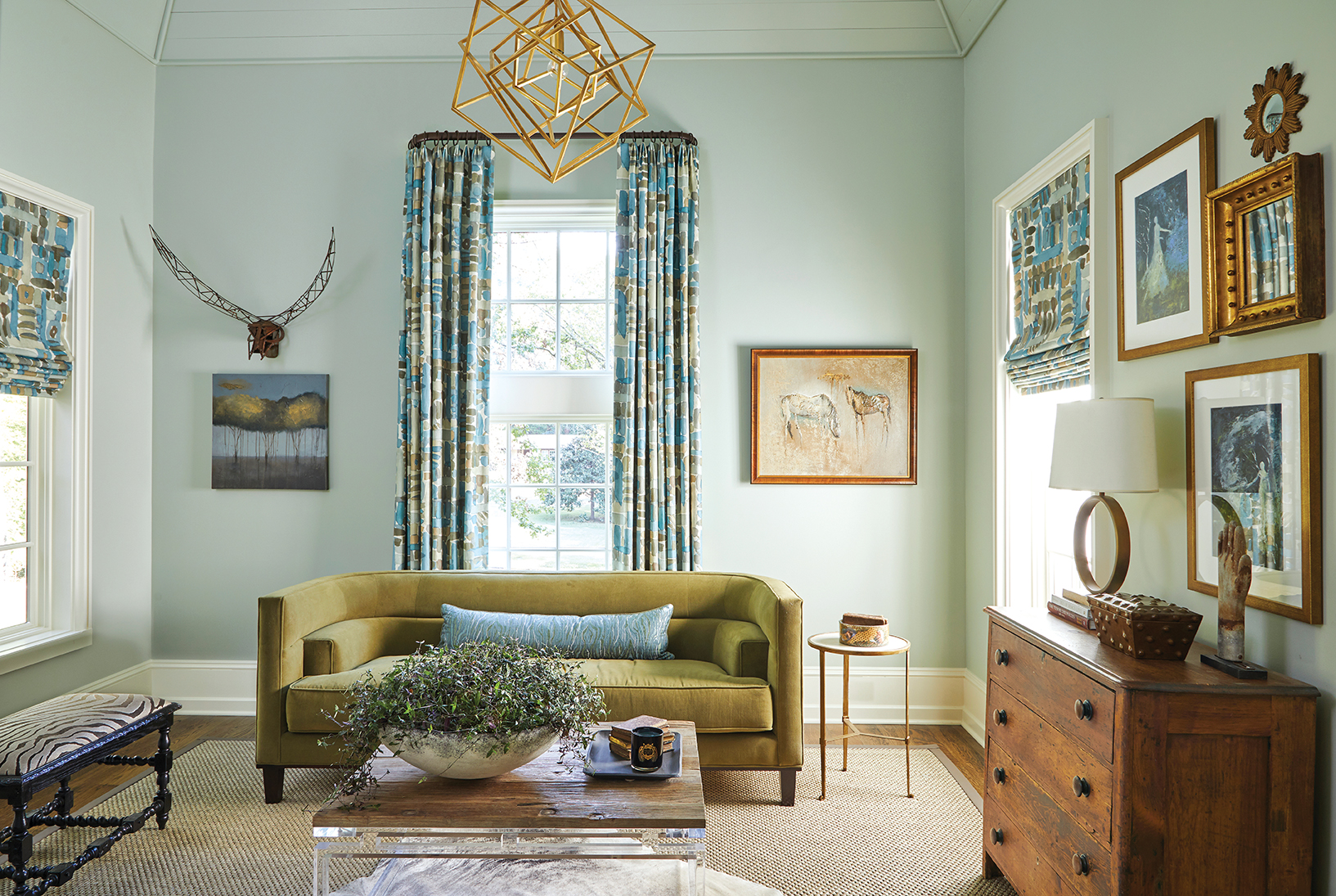 An eclectically styled study with tall ceilings and art packed walls.