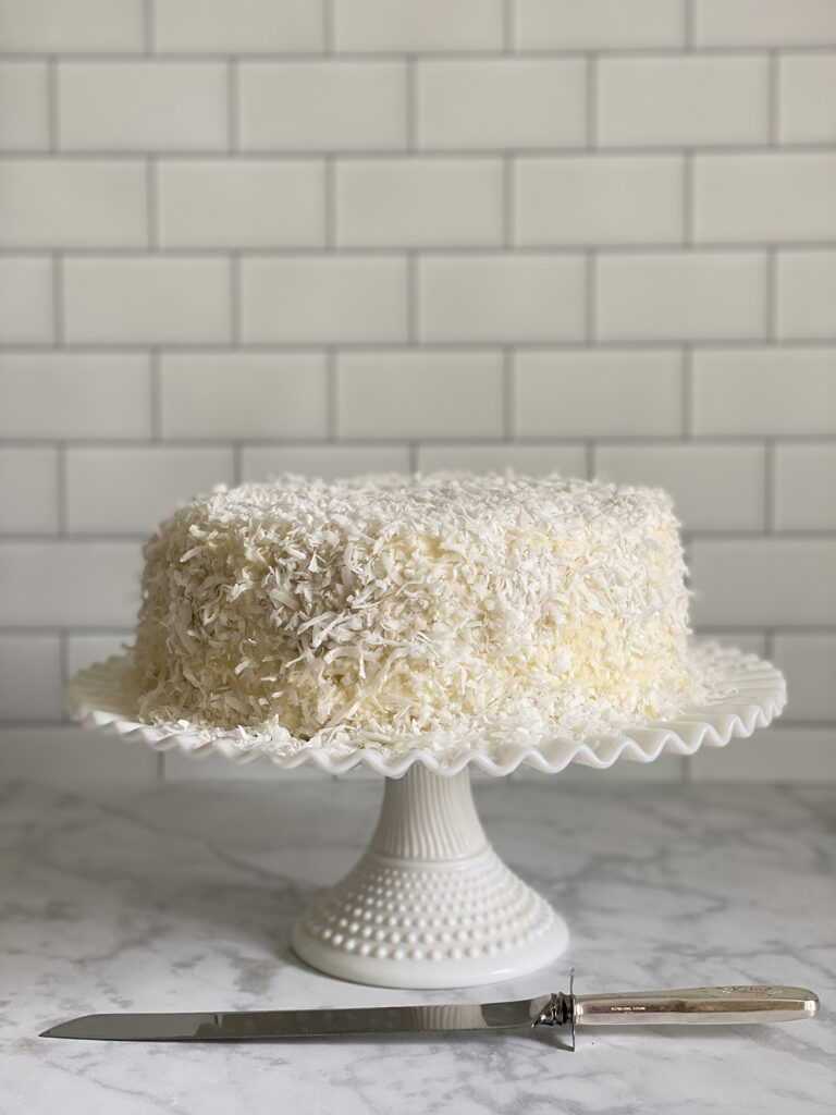 Coconut cake on cake stand.