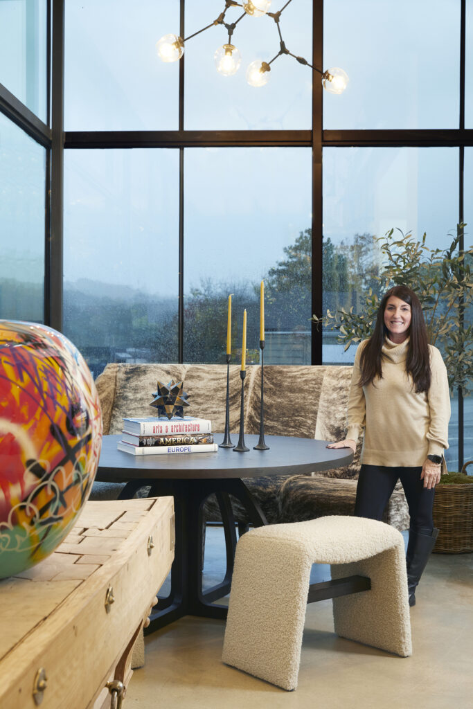 Sherri showing off her favorite banquette in the front show room of Christopher Collection.